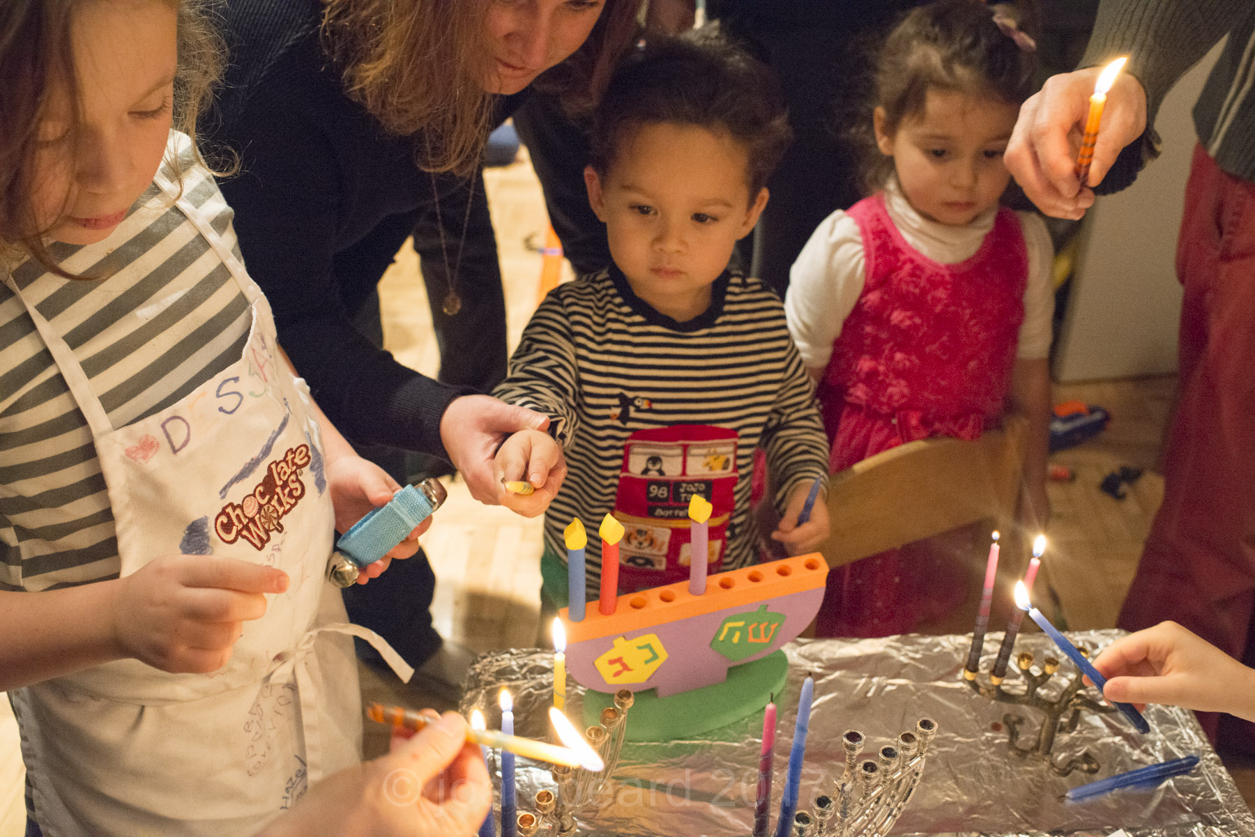 children lighting Hanukkah candles at Family Lab